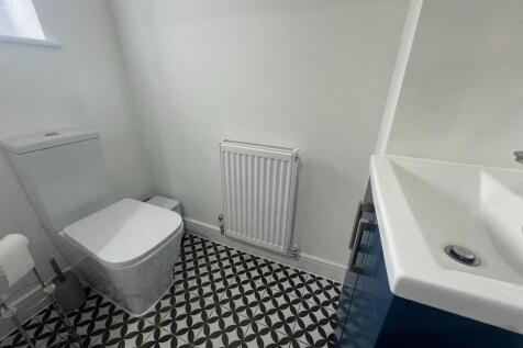 A modern and tidy single toilet room featuring ...