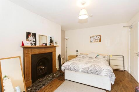 A spacious and inviting bedroom featuring a lar...