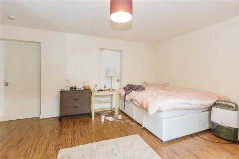 A spacious and bright bedroom featuring a large...