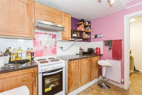 A warm kitchen space featuring wooden cabinetry...