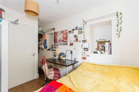 A cozy and colorful single bedroom featuring a ...