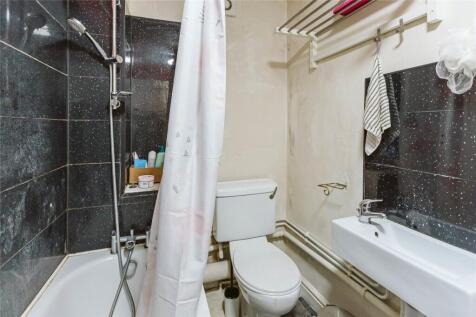 A compact bathroom featuring a bathtub with sho...