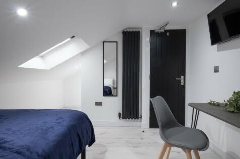This inviting double bedroom features a cozy la...