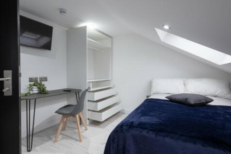 This stylish double bedroom features a cozy atm...