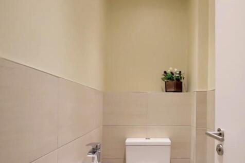 A clean and neatly maintained single toilet wit...
