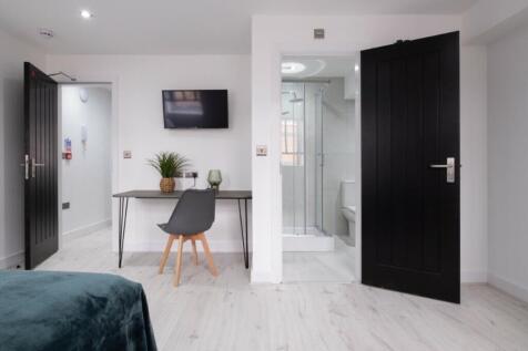 A stylish and well-lit double bedroom complete ...