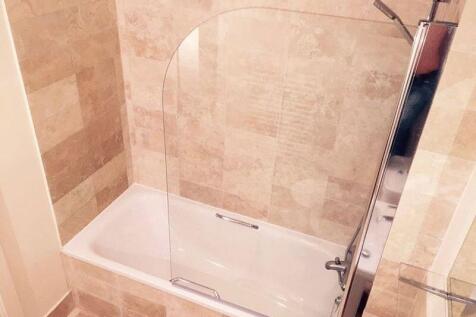 A modern bathroom suite featuring a clean, tile...