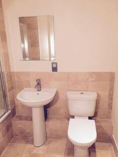 A neat and modern bathroom featuring a white pe...