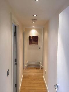 A clean and well-lit hallway featuring smooth w...