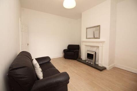 A cozy living room featuring a black leather so...