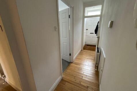 A clean and well-maintained hallway with wooden...