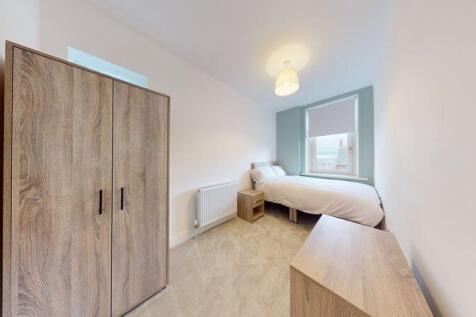 A neat and cozy single bedroom featuring a ward...
