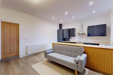Bright and modern living room featuring a styli...