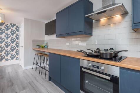 Modern kitchen featuring sleek blue cabinetry, ...