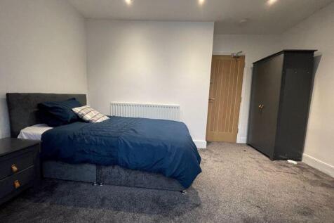 A spacious and modern master bedroom featuring ...