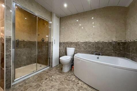 Spacious, modern bathroom suite featuring a lar...