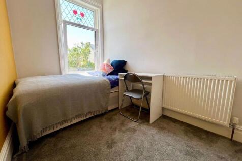 A cozy single bedroom featuring a comfortable b...