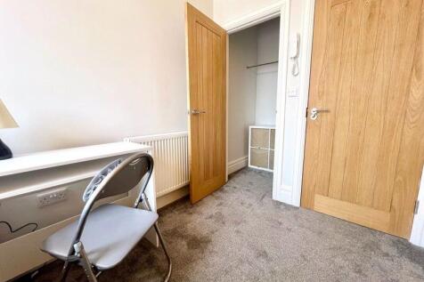 A neat, well-lit single bedroom featuring a mod...