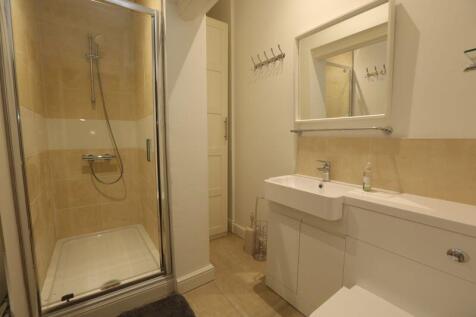 A clean and modern bathroom featuring a glass-e...