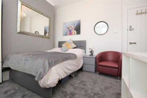 A cozy single bedroom featuring a comfortable b...