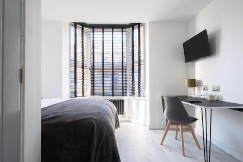 This stylish double bedroom features a large wi...