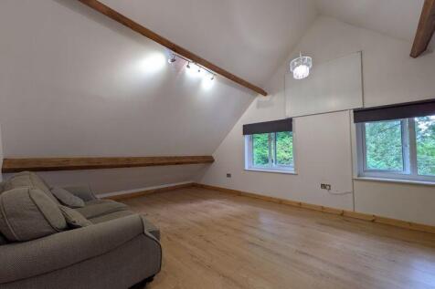 A bright and airy living room featuring high va...