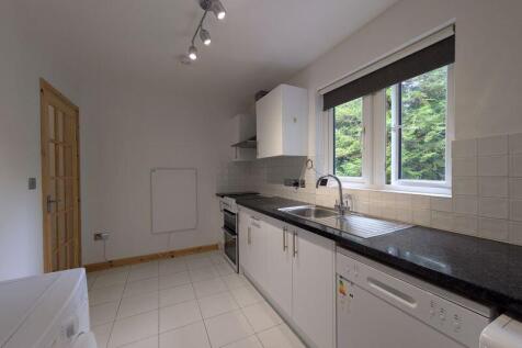 A bright and tidy kitchen featuring modern whit...