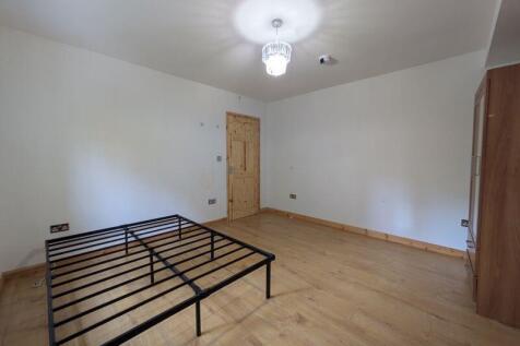 A spacious and clean double bedroom featuring w...