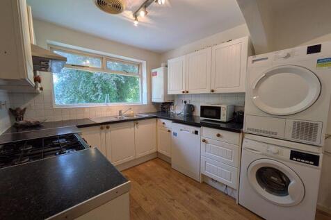 Bright, modern kitchen with plenty of white cab...