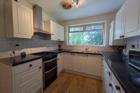 A bright and modern kitchen featuring cream cab...