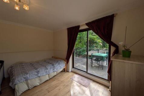A cozy, well-maintained single bedroom with woo...