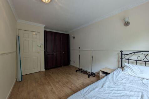 A neat bedroom featuring a single bed with a me...