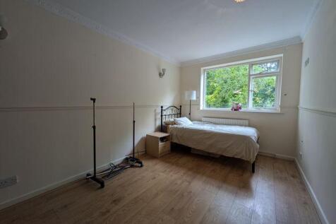 Cozy single bedroom featuring a large window th...