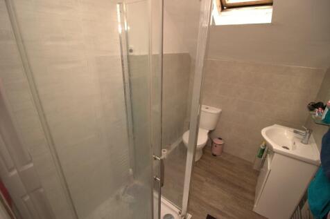 A neat and modern bathroom featuring a glass-en...