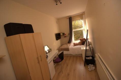 A neat and cozy single bedroom with a window al...