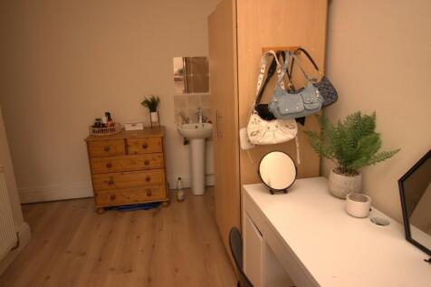 A neat hallway featuring light wooden flooring,...