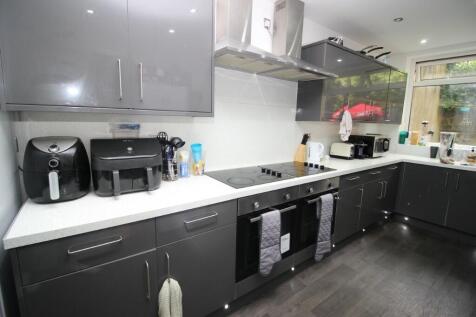 Modern kitchen with sleek black cabinetry, a ra...
