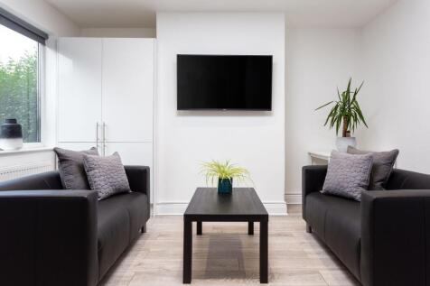 Modern living room featuring two sleek black so...
