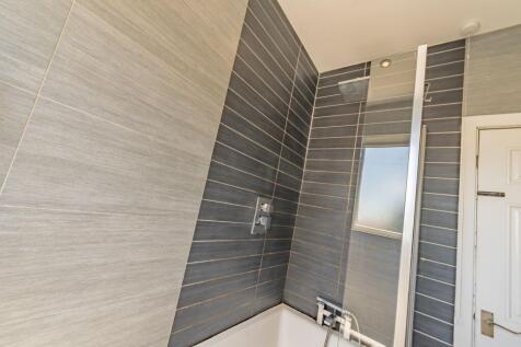 Modern bathroom suite featuring sleek grey tile...
