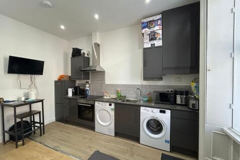 Modern kitchen with sleek dark cabinetry, integ...