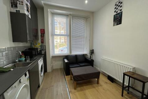 Bright and tidy living room featuring natural l...