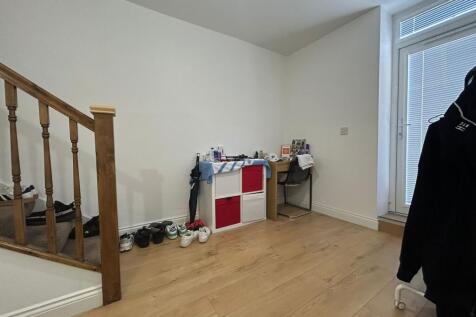 Bright and tidy hallway with wooden flooring, a...