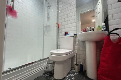 A modern bathroom featuring a glass-enclosed sh...
