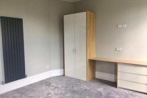 A bright and tidy master bedroom featuring soft...