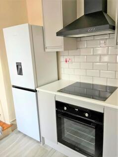 A modern kitchen featuring a clean white counte...