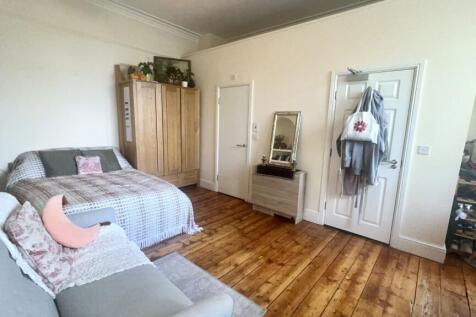 A spacious and bright bedroom featuring a doubl...