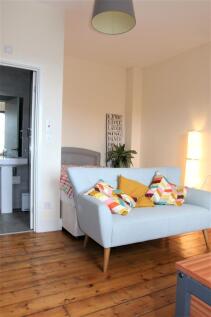 A cozy double bedroom featuring warm wooden flo...