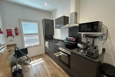 Modern kitchen space with sleek dark cabinetry,...