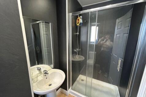 A modern bathroom featuring a sleek glass-enclo...