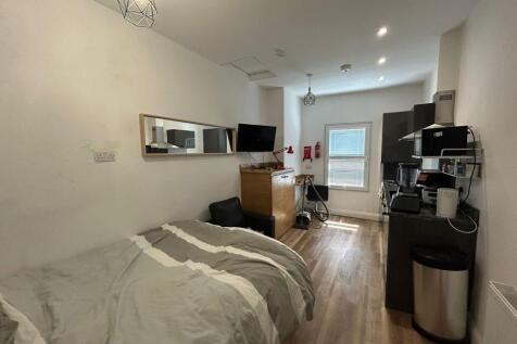 A cozy single bedroom with a neatly made bed, w...